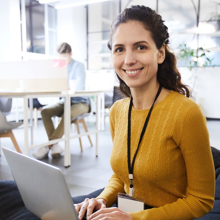 beautiful-woman-with-badge-working-in-cozy-office-QDHEW9K.jpg